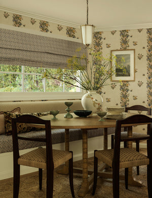 Bea floral motif ceramic vase by Heidi Caillier filled with stems styled on a dining table.