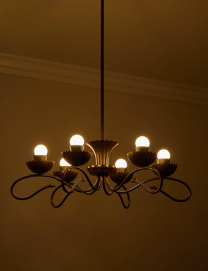 Houghton six arm iron chandelier by Heidi Caillier with the lights turned on