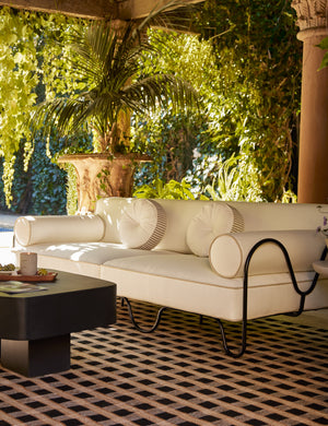 Littu Indoor / Outdoor Striped Disc Pillow by Sarah Sherman Samuel in Brown styled on an outdoor sofa.