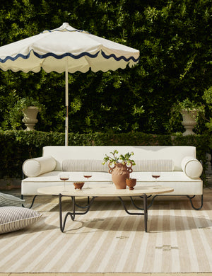 Littu Indoor / Outdoor Striped Bolster Pillow by Sarah Sherman Samuel in Brown styled on an outdoor sofa.