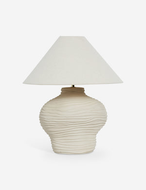 The Wrinkle Table Lamp by Sarah Sherman Samuel features a cream-colored, wavy-textured ceramic base and a wide conical fabric shade in matching neutral tones, shown against a plain white background.