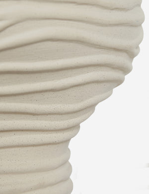 Close-up of the beige, textured surface of the Wrinkle Table Lamp by Sarah Sherman Samuel, featuring sculptural wavy ridges that create a natural look against a plain white background.