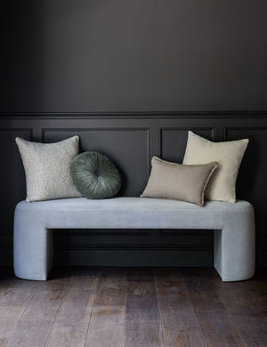 Charlotte oyster white square velvet pillow sits on an ice blue velvet bench with other throw pillows
