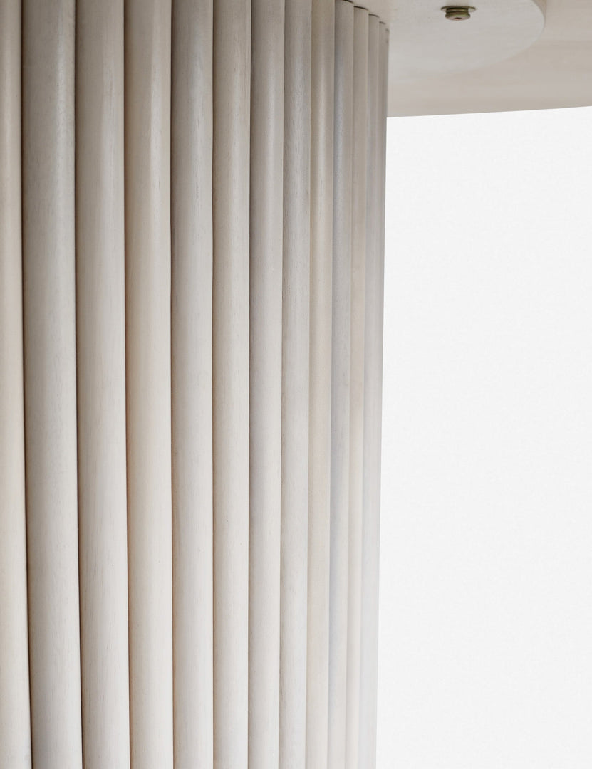 | Close-up of the textured paneling of the white-washed acacia wood on the pedestal base of the Rutherford round dining table.