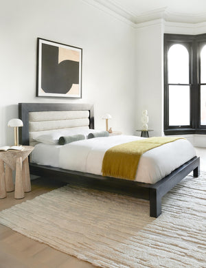 The European Flax Linen white Duvet Set by Cultiver is tucked into a gray boucle and black framed bed in a bedroom with a textured cream rug, a mustard toned throw blanket, and sage green velvet lumbar pillows