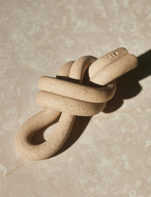 Angled view of the Overhand natural speckled ceramic Knot decorative object by SIN