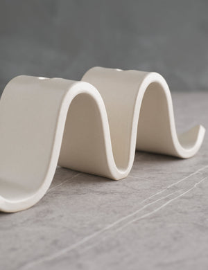 Angled view of the Wyn White Candelabra by SIN with an undulating silhouette and space for two taper candles