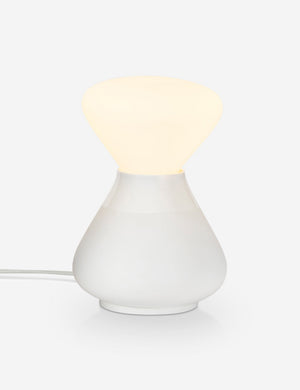 The Reflection Noma white table lamp by Tala with its light on
