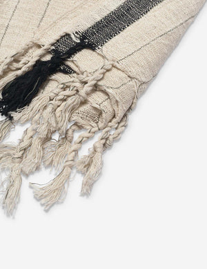 Close-up of the tasseled edge on the Malla handwoven natural and black striped turkish cotton towel by House No. 23